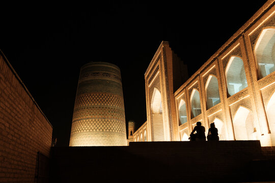 Illuminated Kalta Minor minaret and ancient madrasa at night in Khiva, Uzbekistan