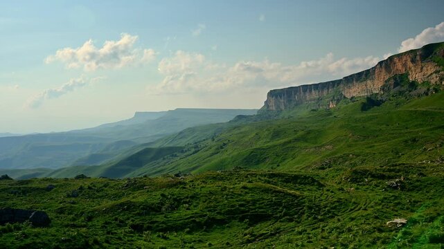 Panoramic view of green mountain landscape and rock cliff