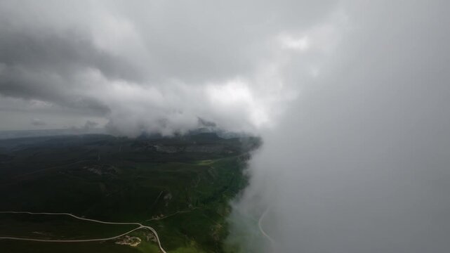 Aerial view of winding mountain road under storm clouds