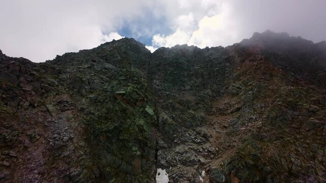 Aerial view ascending rocky mountain ridge with snow patches