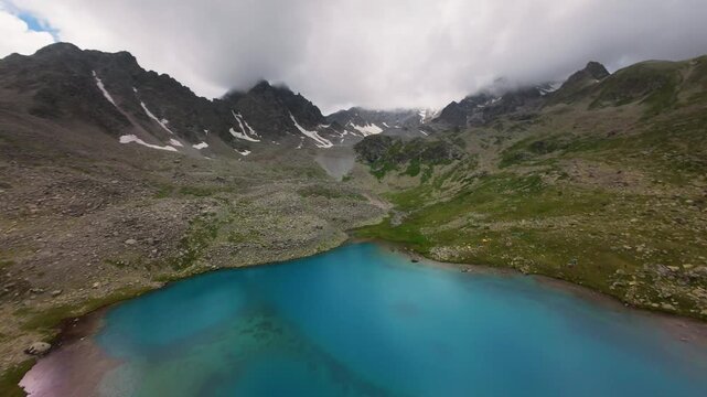 Aerial view of turquoise alpine lake and mountain peaks