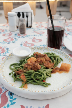 Traditional Uzbek green noodle dish with meat and sour cream in Khiva, Uzbekistan