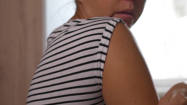 Woman wiping arm with alcohol pad before glucose sensor application