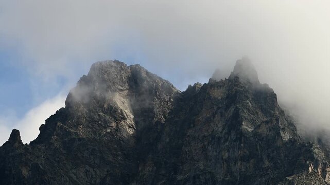Timelapse of clouds moving over rugged mountain peaks
