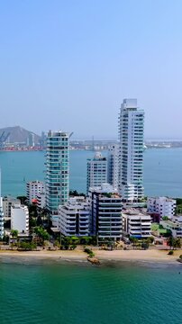 Aerial view of the modern skyline and coastline of Cartagena, Colombia, featuring high-rise buildings, sandy beaches, and the Caribbean Sea