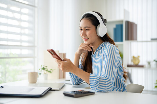 Smiling asian woman wear headphone listen to music select playlist on smartphone. Leisure Time,