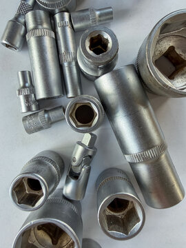 Detailed flat lay of silver socket wrenches and heads for automotive repair.
