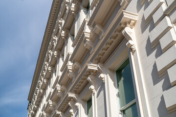 Detailed Close-Up of Ornate White Classical Building Facade Against Clear Sky © MarshallChan