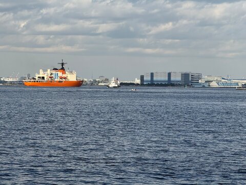 Orange icebreaker Shirase sailing in Yokohama Port under a cloudy sky in Yokohama Kanagawa Japan