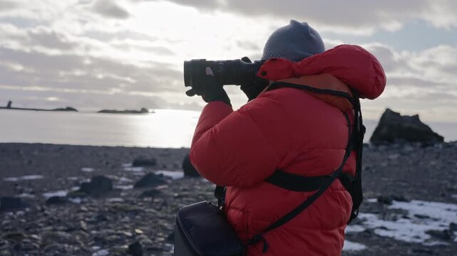 Tourist taking photos with telephoto camera in Antarctica