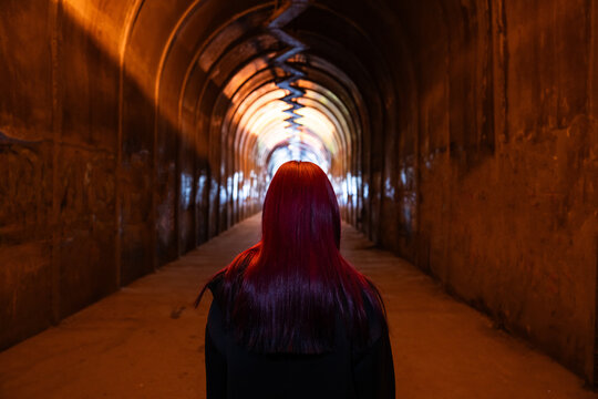 A girl walks through a tunnel alone