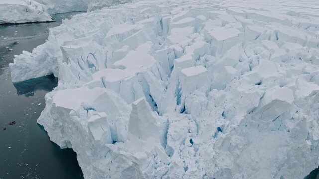 Massive Crevassed Glacier Above Dark Ocean Drone View