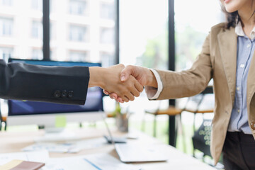 Business partners shaking hands, forming an agreement and showing collaboration, trust, and partnership during a professional meeting in a modern office © David