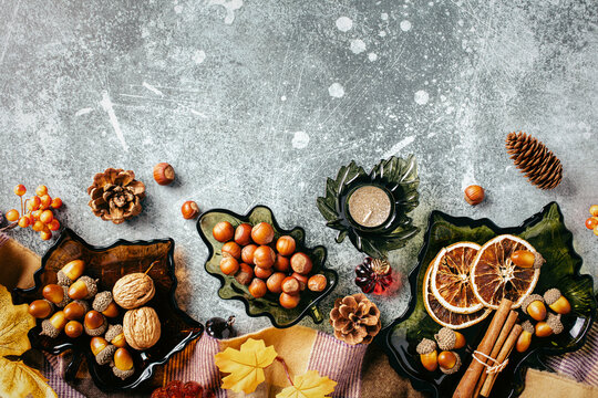 Autumn background with leaf glass dishes, nuts and cozy plaid blanket