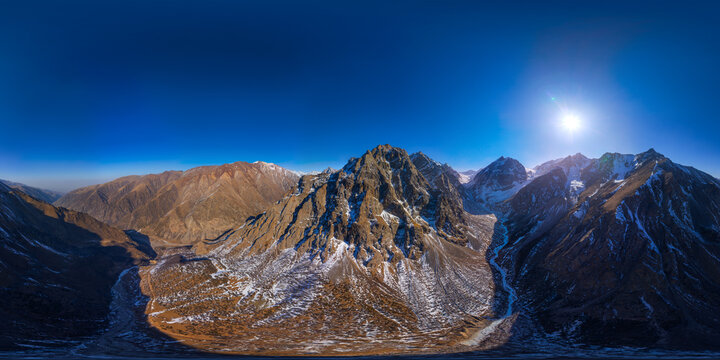 Rugged Mountain Range Panorama with Snow and Blue Sky