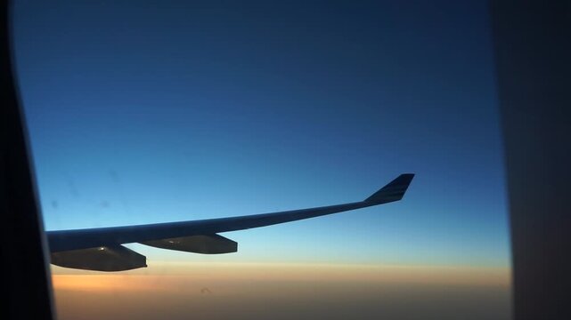 Commercial Airplane Wing Silhouette In Clear Blue Sky Window Perspective High Altitude Flight Passenger Perspective Travel Vacation Destination Transportation Aviation Concept Scenic View