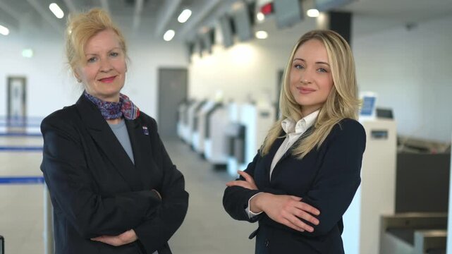 Two confident airline ground staff women standing in the airport