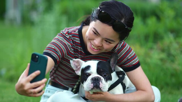 Japanese woman taking a selfie with her french bulldog