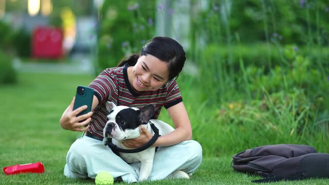 Young woman taking a selfie with her dog in the park