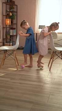 Two little sisters playing and smiling at home