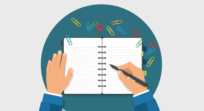 Hand writing in open notebook with paperclips and colorful supplies