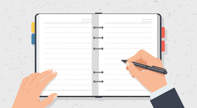 Hand writing in open notebook with pen and planner pages