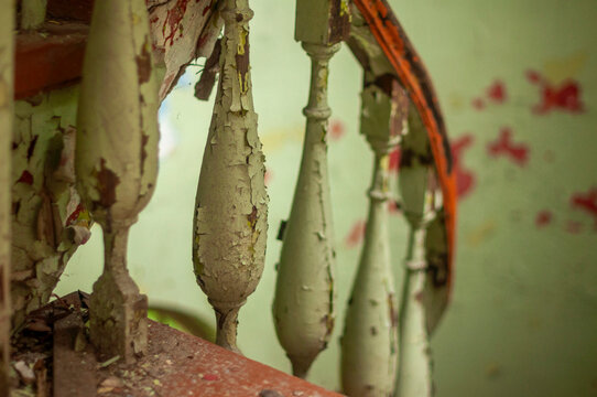 Abandoned overgrown mansion with spiral staircase, old car and ruined interior