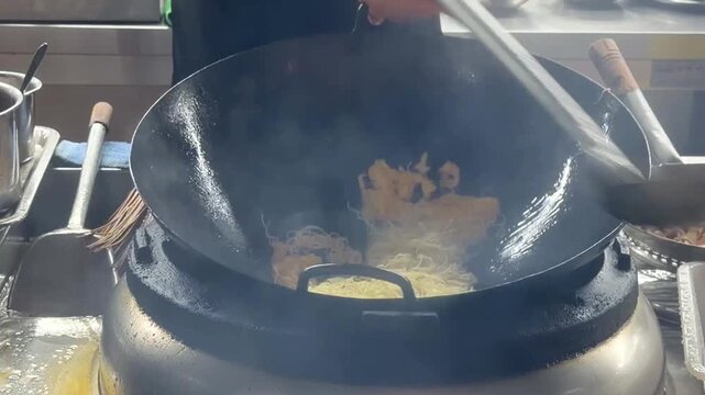 Hands Cooking Noodles and Vegetables in Wok &ndash; Chinese Restaurant Kitchen