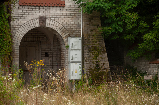 Abandoned overgrown mansion with spiral staircase, old car and ruined interior