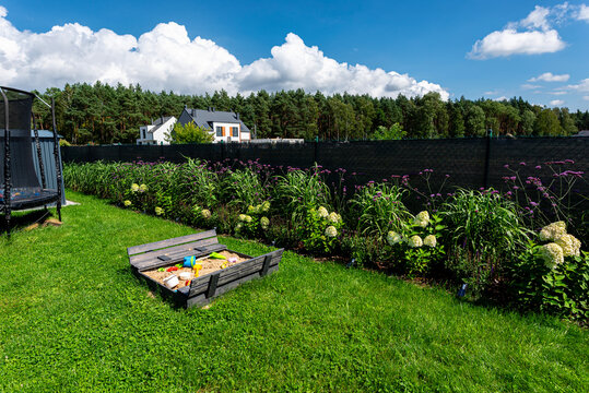 Backyard garden with sandbox and various plants