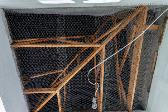 Attic space showing wooden trusses with safety netting