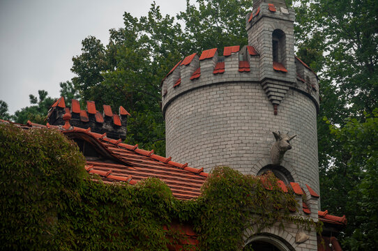 Abandoned overgrown mansion with spiral staircase, old car and ruined interior