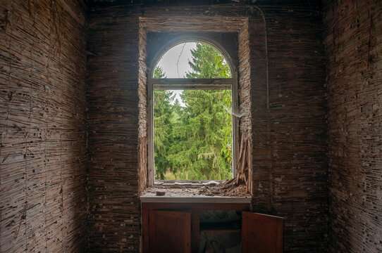 Abandoned overgrown mansion with spiral staircase, old car and ruined interior
