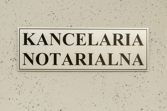 Tablica informacyjna z napisem Kancelaria Notarialna na elewacji budynku.