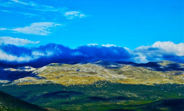 Blue fluffy clouds above the mountain valley horizon in wonderful green nature