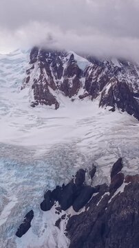 Aerial view of a massive glacier and snow covered mountain peaks in Patagonia, Argentina
