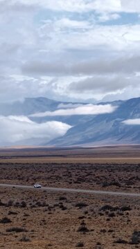 Car driving on a lonely road through the vast landscape of Patagonia, Argentina