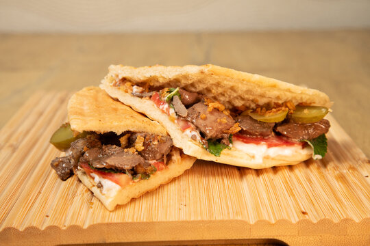 Un plat de restaurant libanais avec du pain et de la viande sur une planche en bois