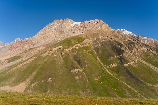 Ridge leading toward Petrovsky Peak near Lenin base camp under clear blue sky in August