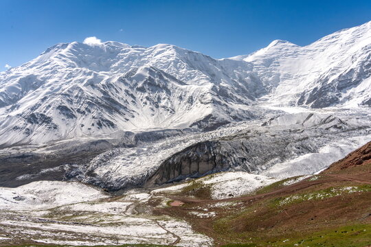 Glacier and snow-capped ridge near Lenin Peak under clear blue sky, August