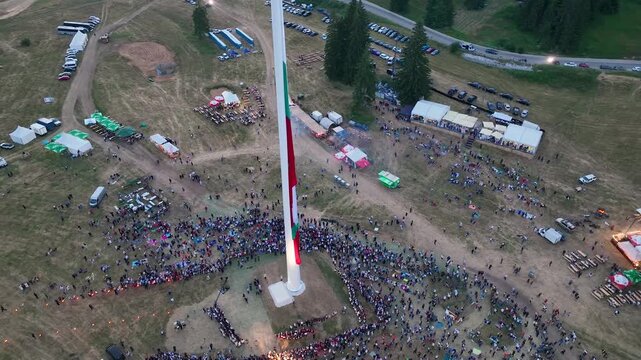 Drone View of Raising the largest and tallest Bulgarian flag on the highest pole on Rozhen Peak in the Rhodope Mountains, near Pamporovo resort, Bulgaria.