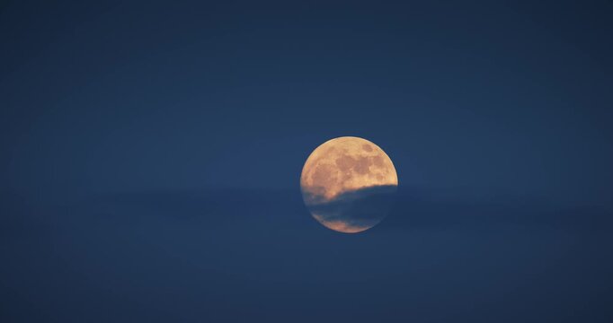 Full moon in deep blue twilight sky above misty horizon, nature video time lapse timelapse