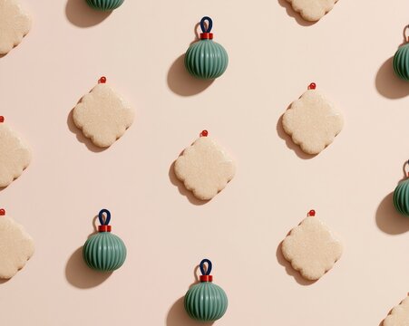 Plain shaped biscuits and green glass ornaments arranged in a repeating grid on a warm blush background for festive packaging and patterns