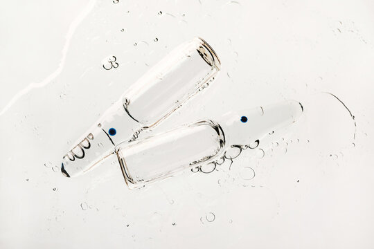 Two transparent glass ampoules containing clear liquid
