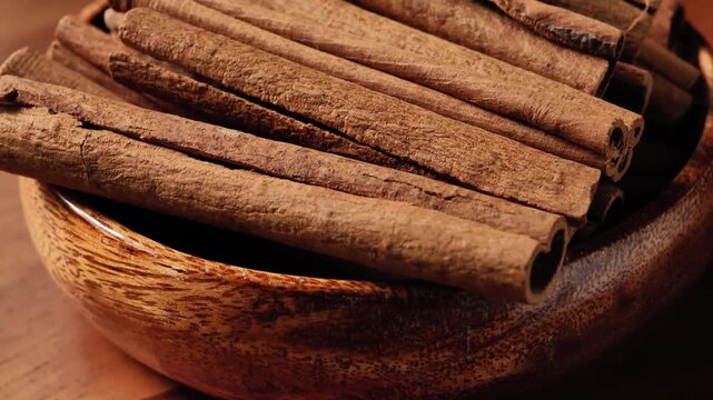 Dried Cinnamon Sticks Spinning in a Wooden Bowl