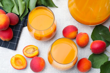 Apricot juice, fresh fruits and leaves on light table, above view © New Africa