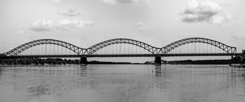 Arching steel bridge panorama over Connecticut River in black and white color