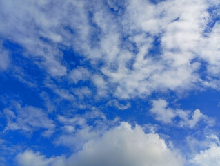 Dramatic altocumulus clouds drifting across a blue sky with cloud pattern white clouds cloudy sky nature background © difre