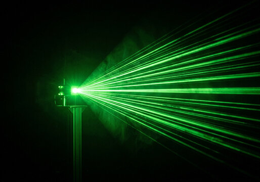 Bright green laser beams projecting light rays in dark space for stage show effects