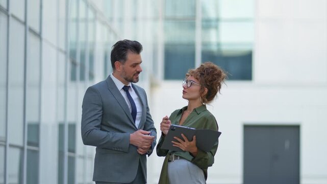 Two business colleagues discussing a project outdoors